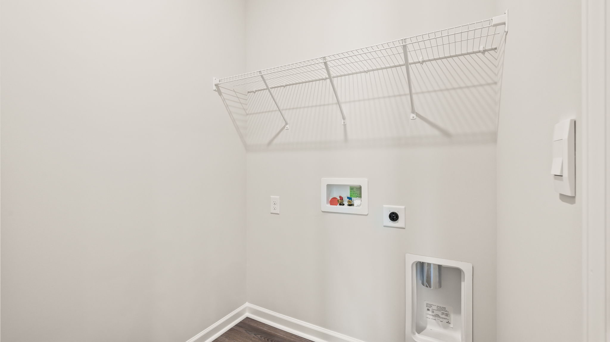 Laundry room with washer/dryer inlets and wire rack shelving