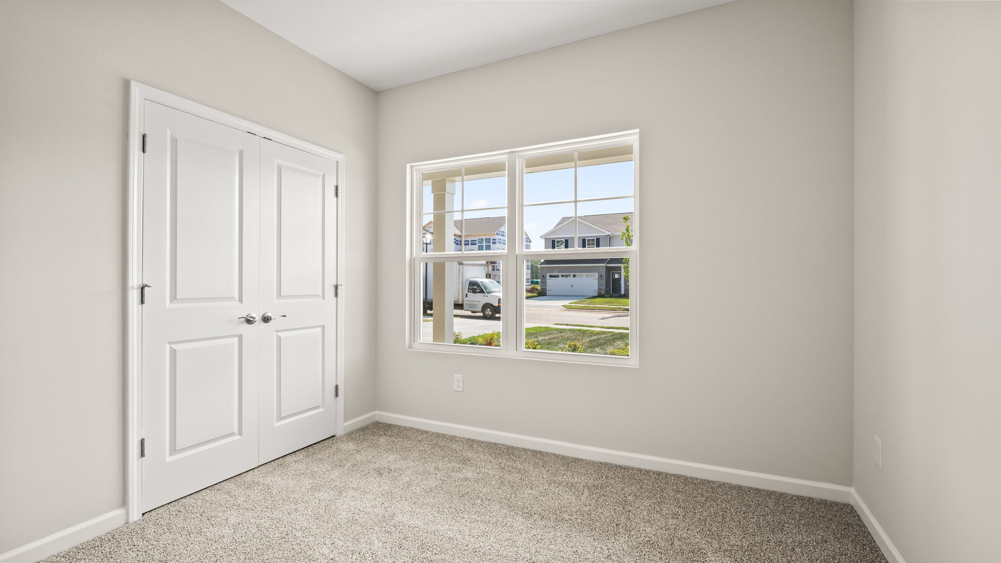 Carpeted bedroom with window and closet door