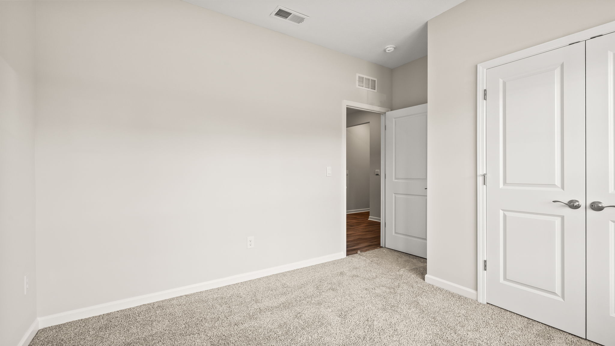 Carpeted bedroom with window and closet door