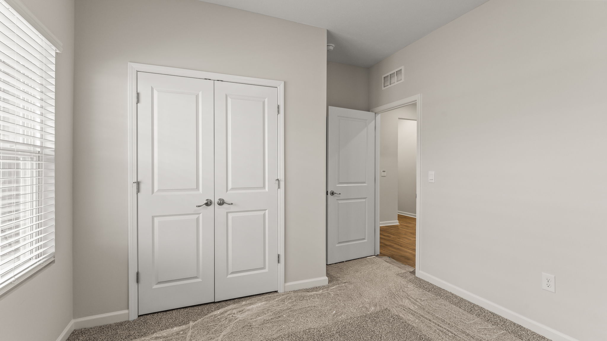Carpeted bedroom with closet door