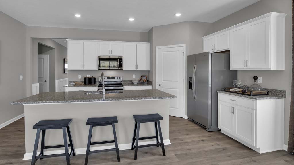 Full kitchen with island, appliances, and white cabinets.