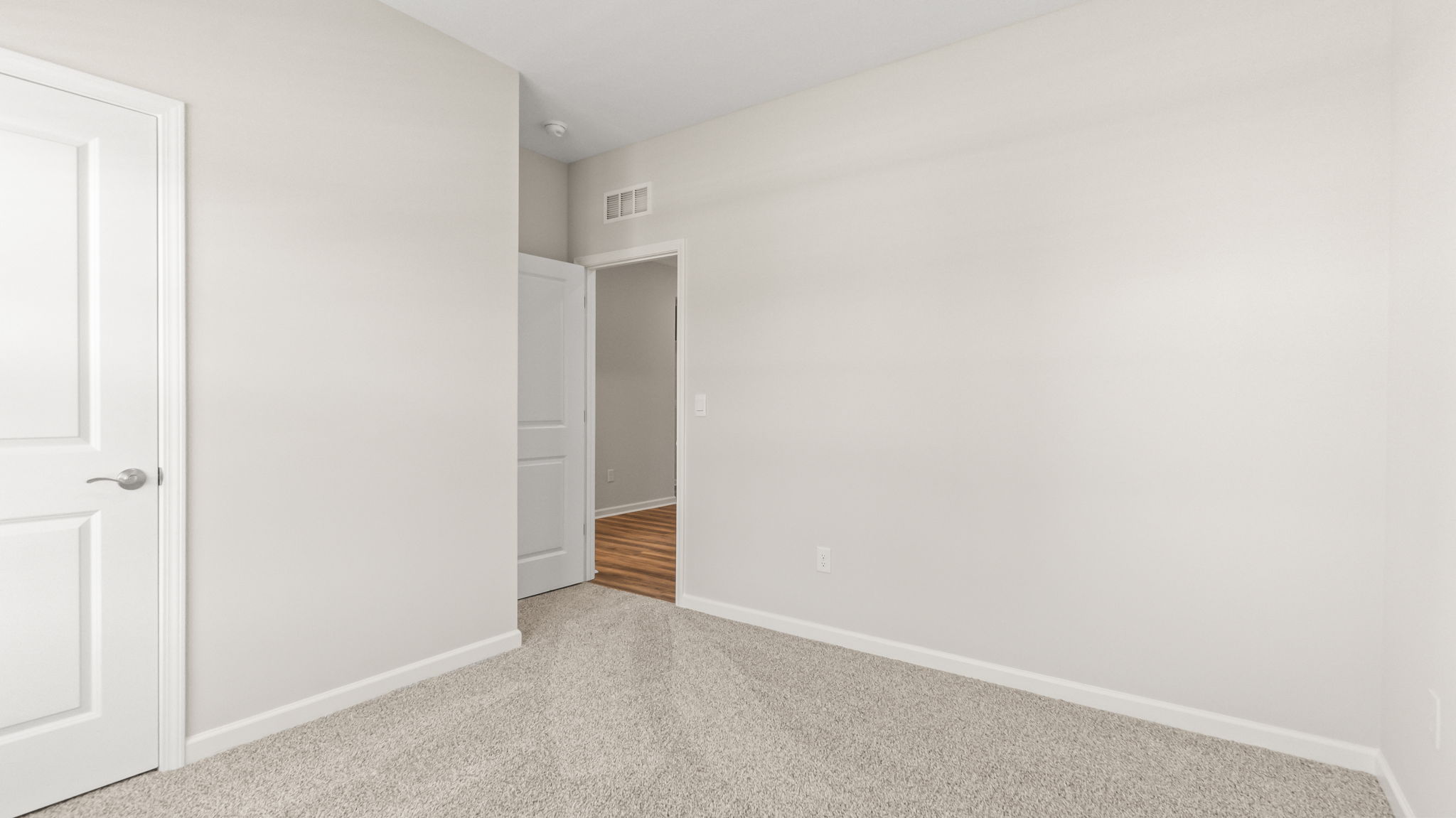 carpeted bedroom with doors to closet and hallway