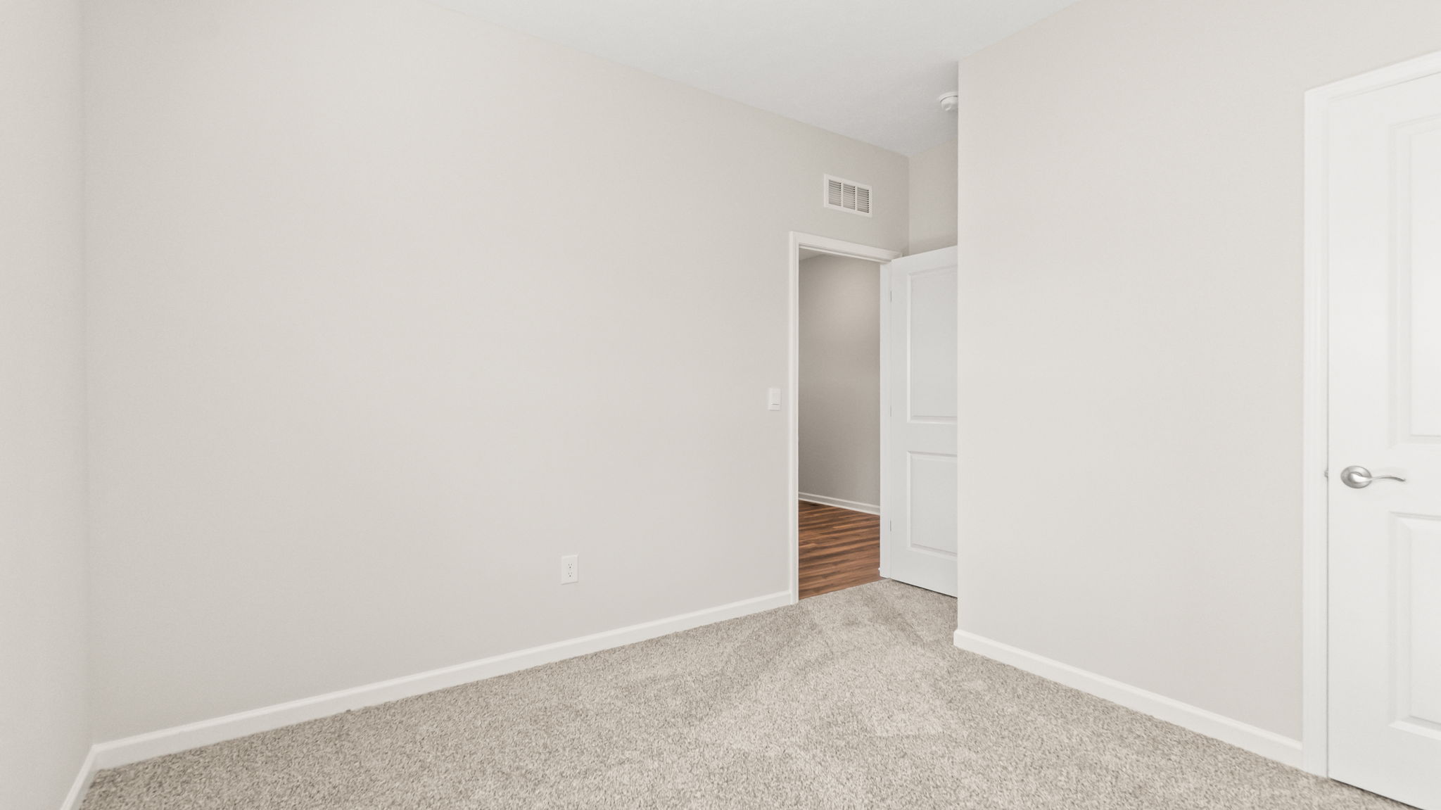 carpeted bedroom with doors to closet and hallway