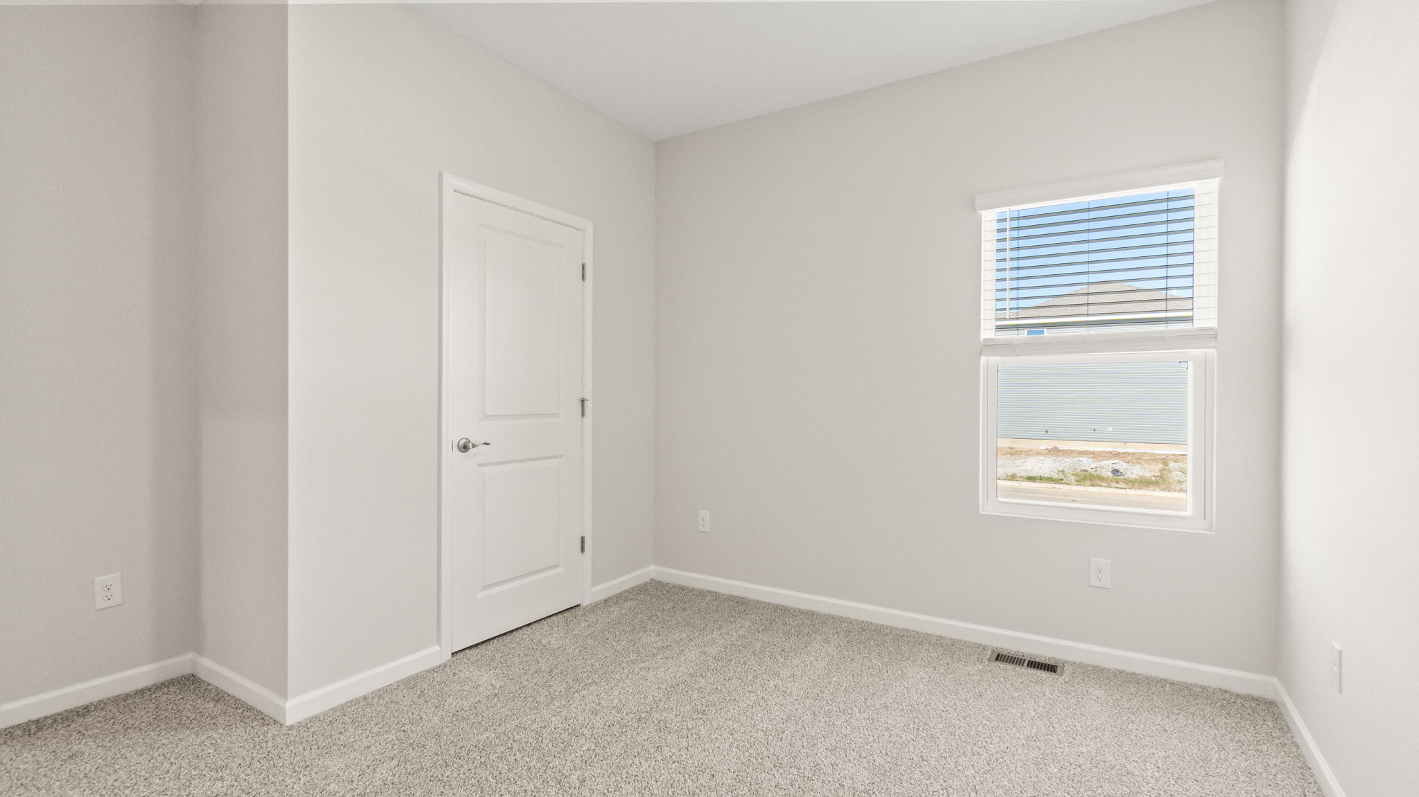 carpeted bedroom with doors to closet and hallway