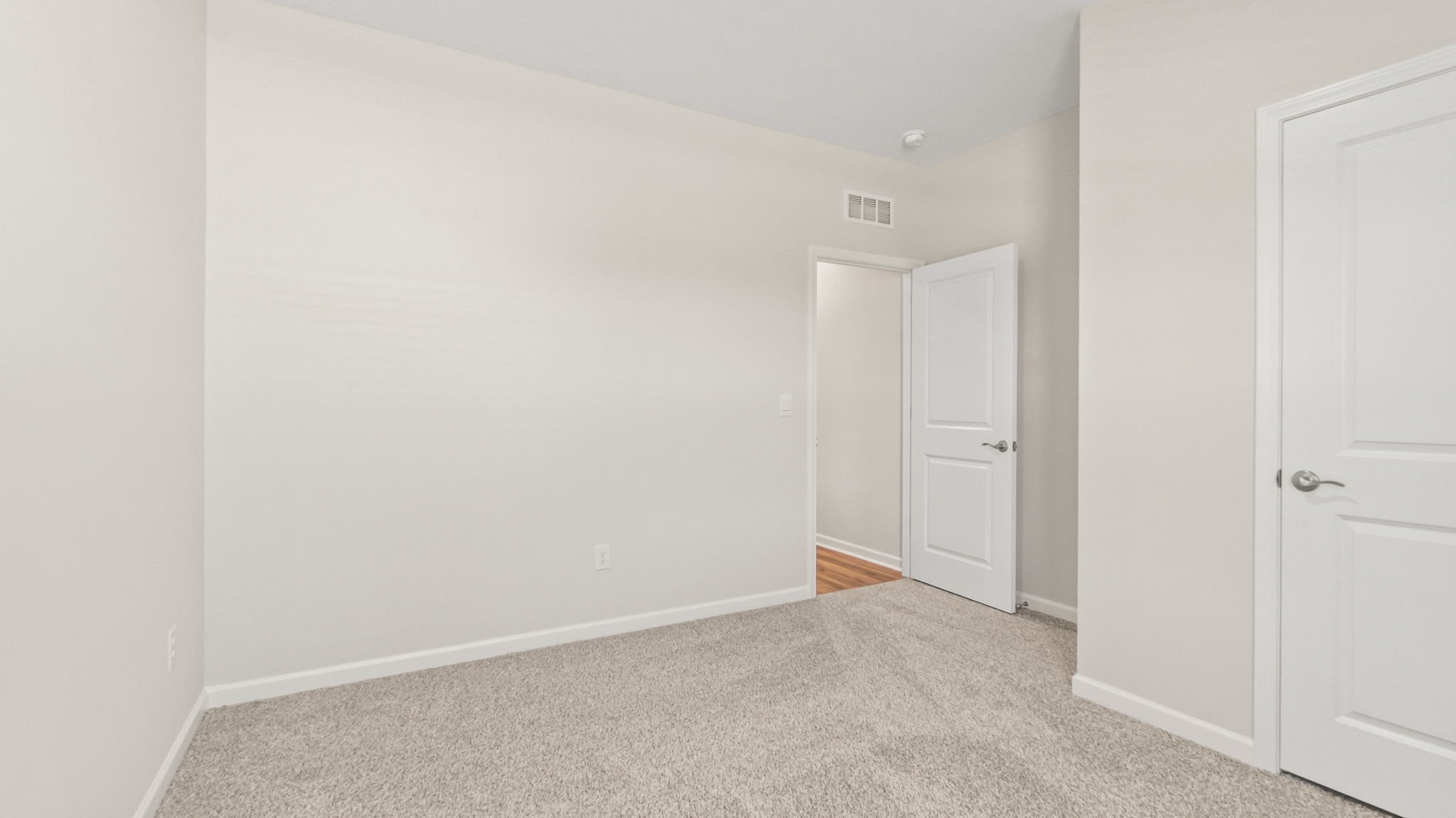 carpeted bedroom with doors to closet and hallway