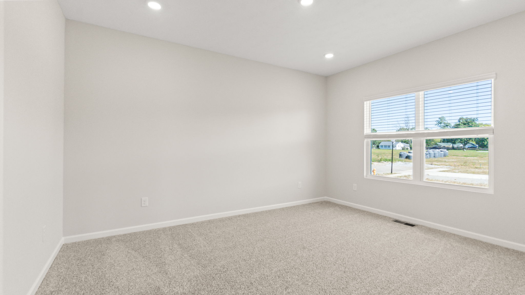 Carpeted primary bedroom with window
