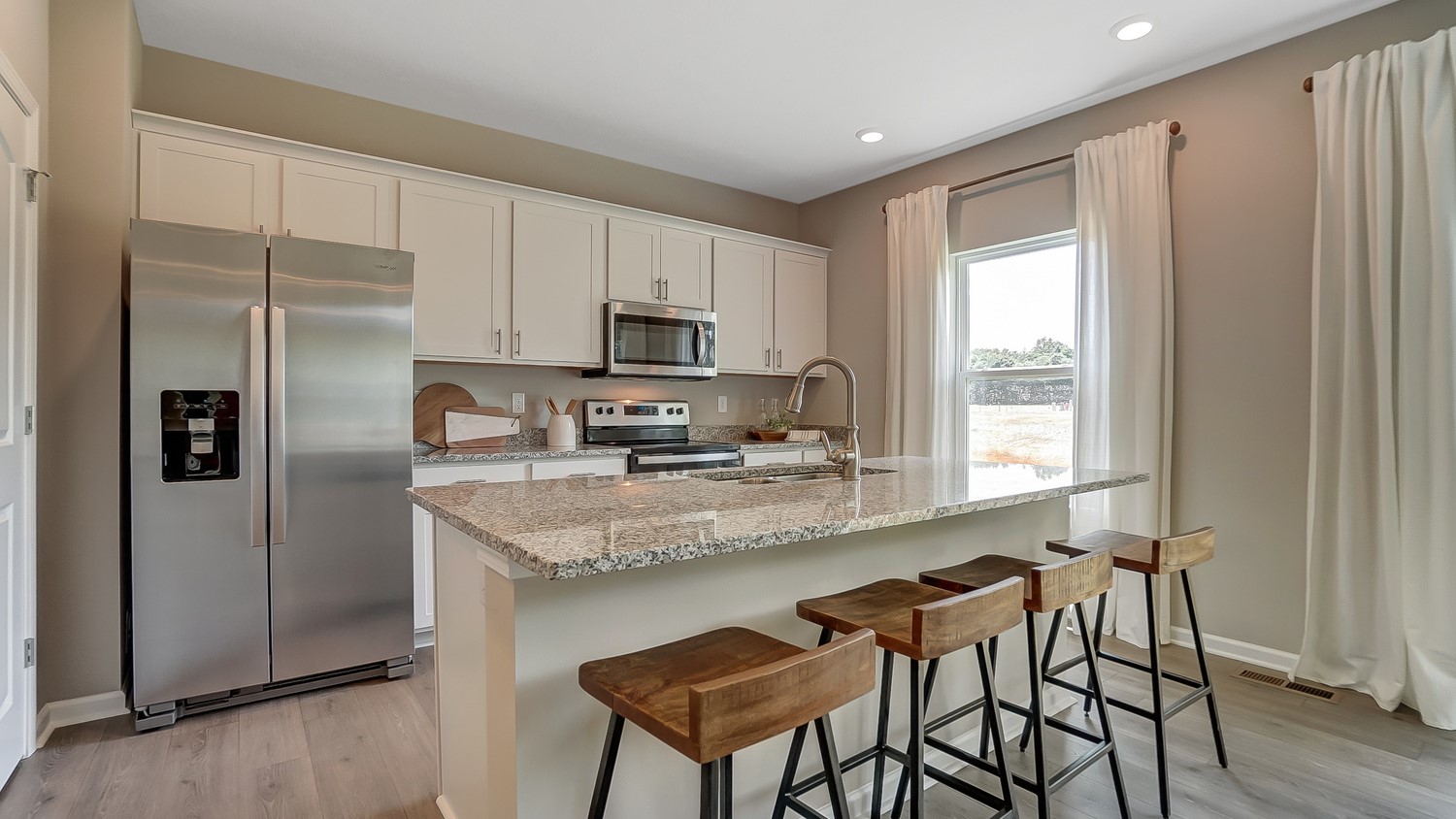 View of the kitchen showing large kitchen island and stainless steel appliances.