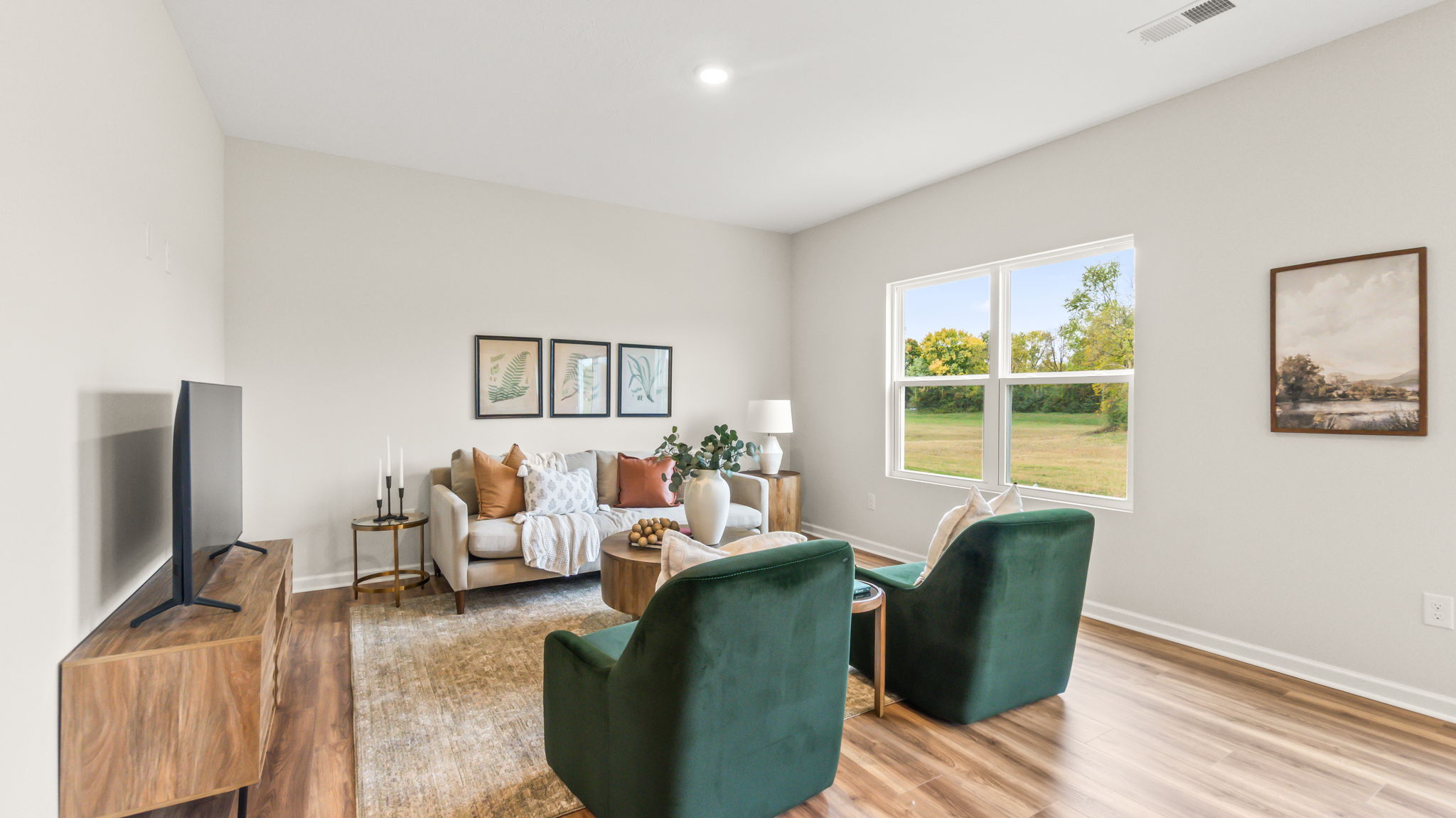 Living room with two green suede chairs and sofa with pillows