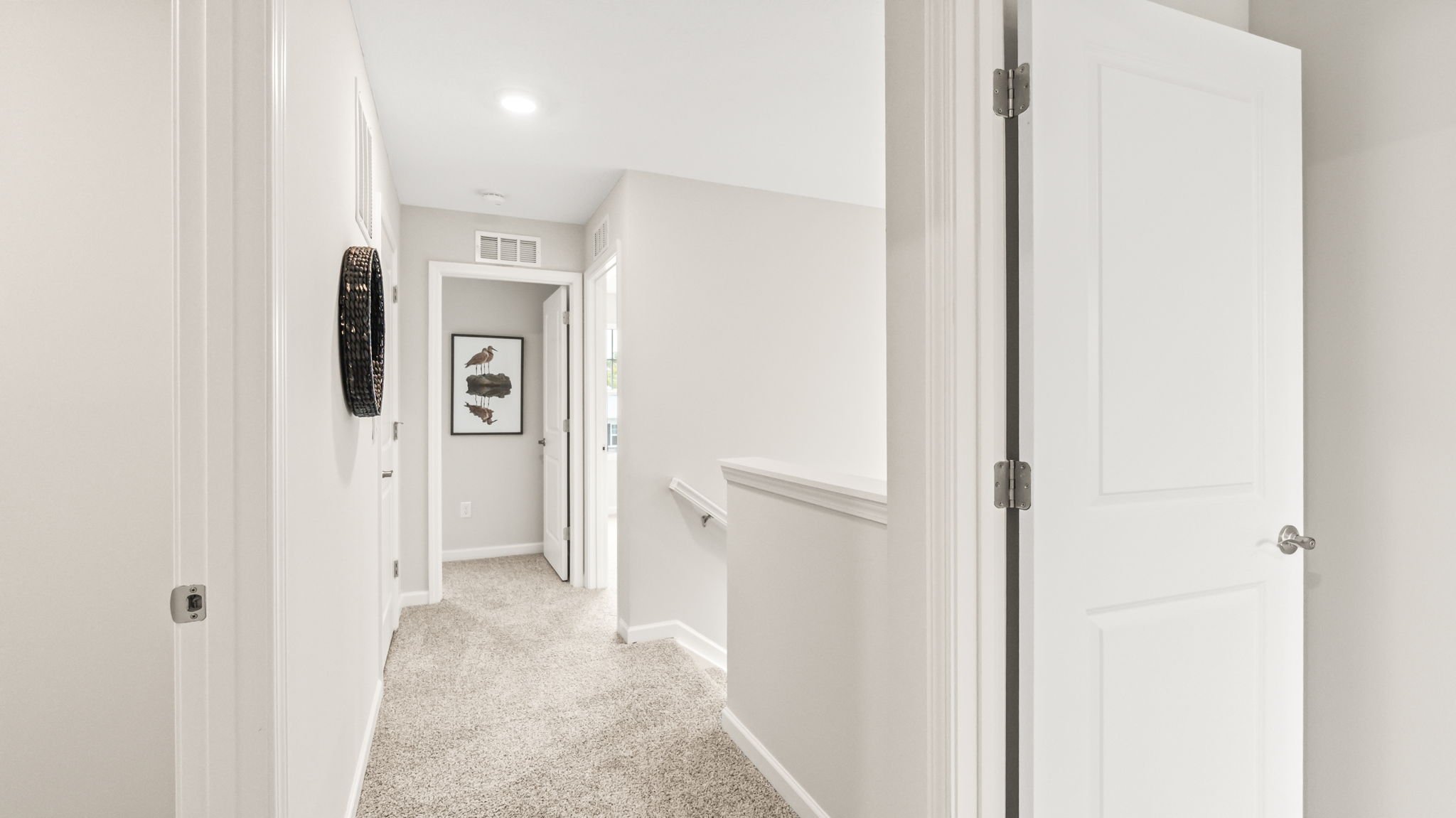 Upstairs hallway with carpet leading to bedrooms