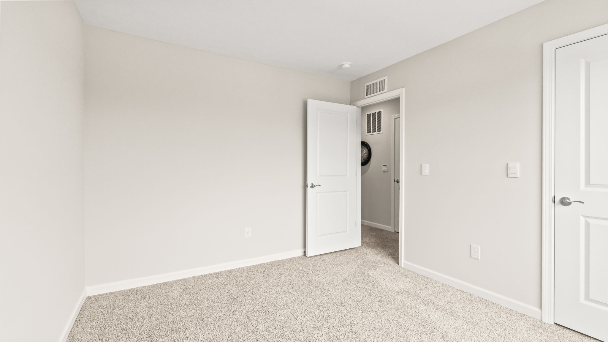 Carpeted bedroom with door to hallway