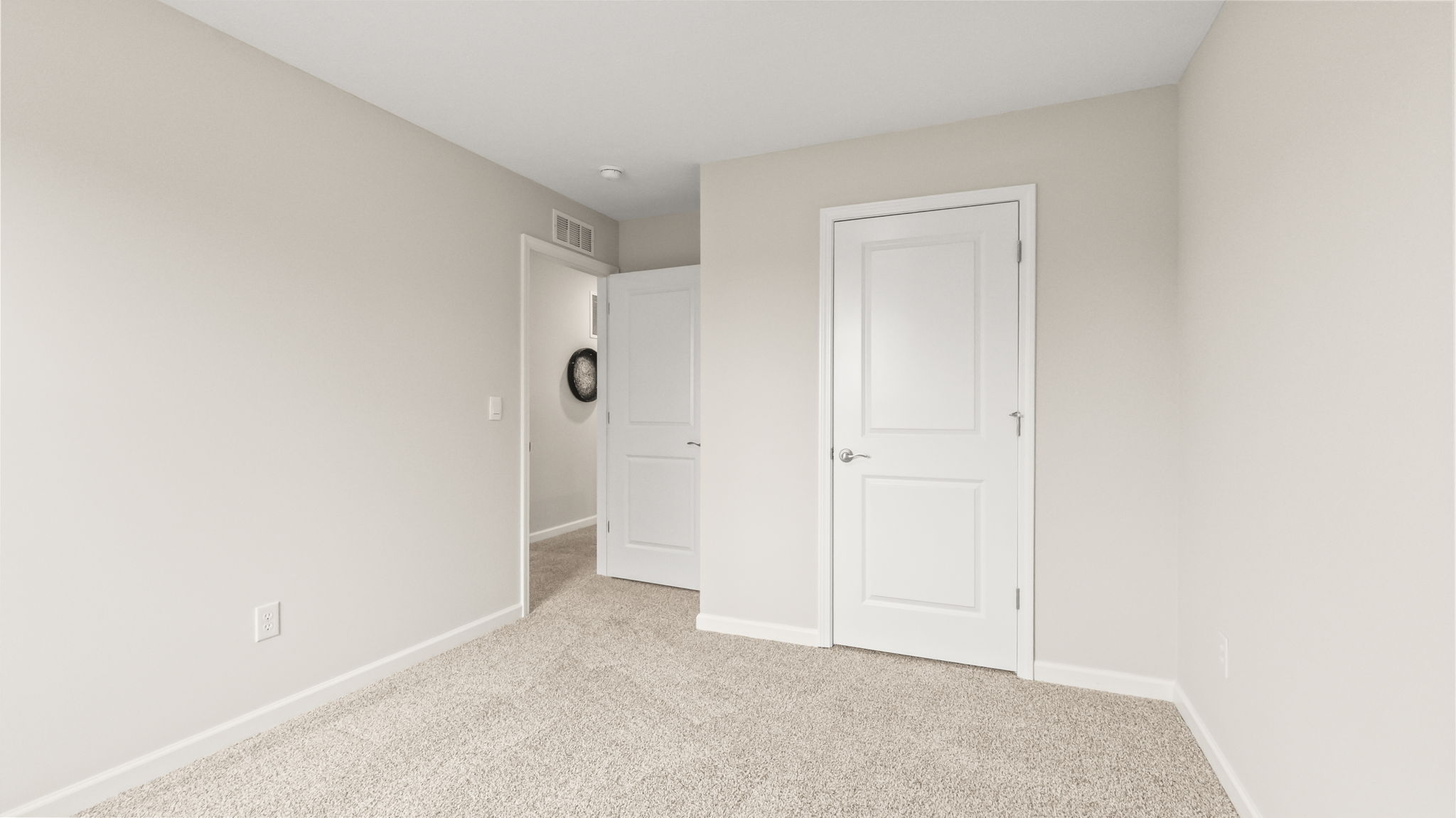 Carpeted bedroom with door to hallway