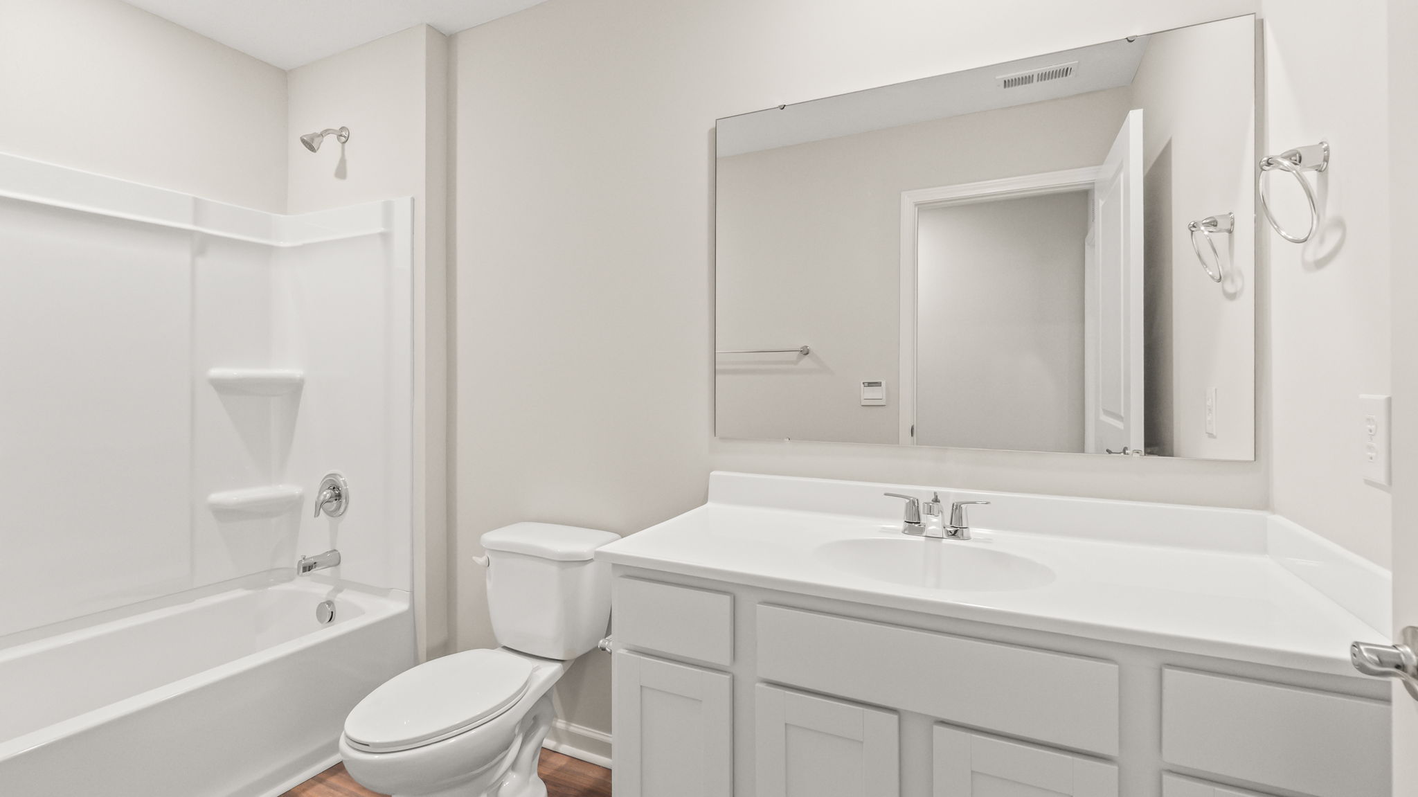 Bathroom with tub, toilet, and sink with mirror