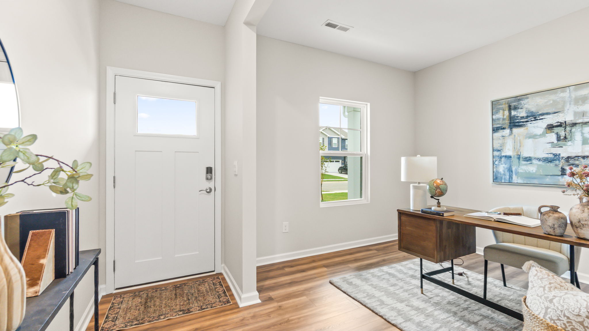 Front of home with door to the home on the left and home office arrangement on the right of frame