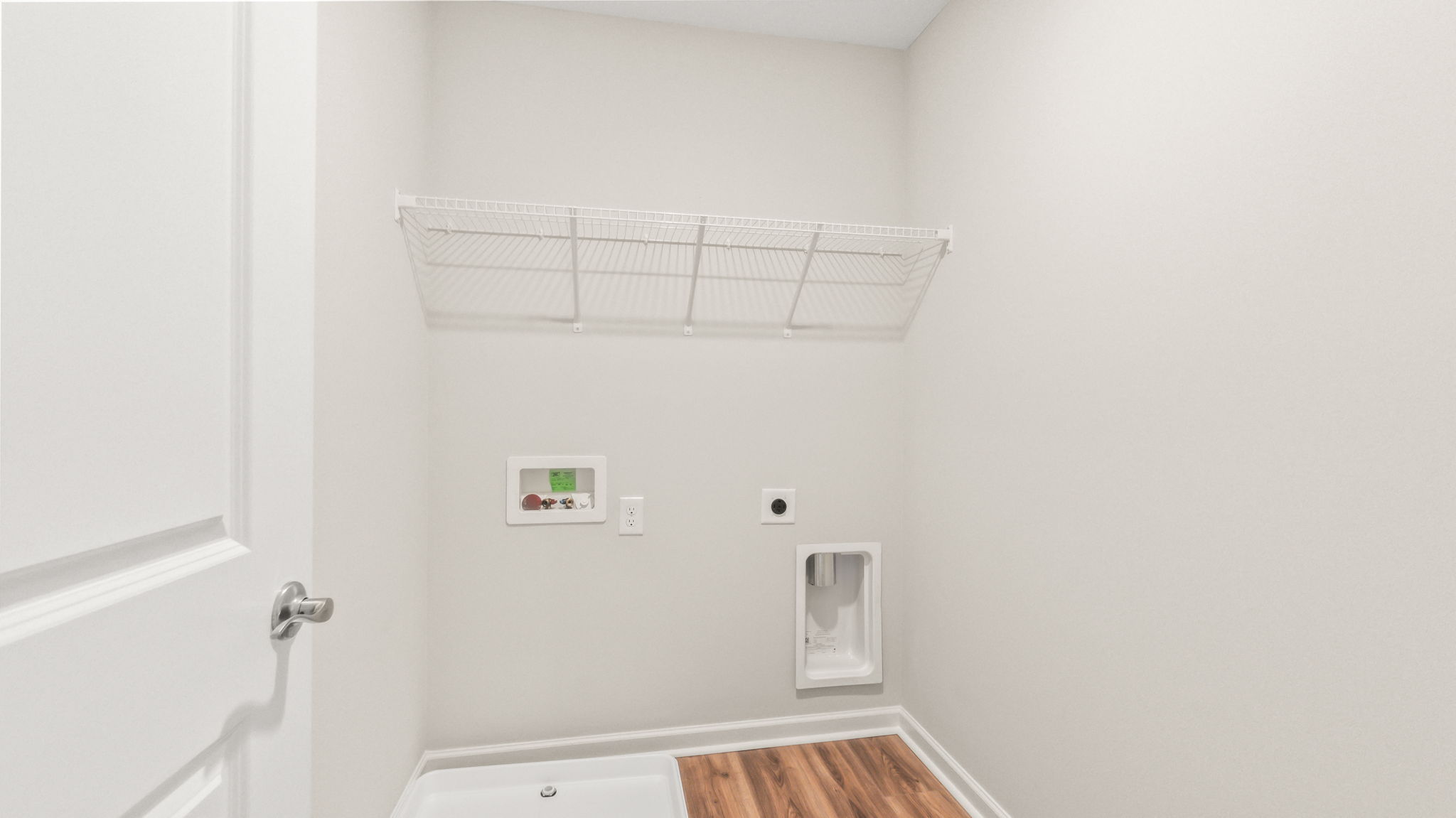 Laundry area with washer/dryer inlets and wire rack shelving