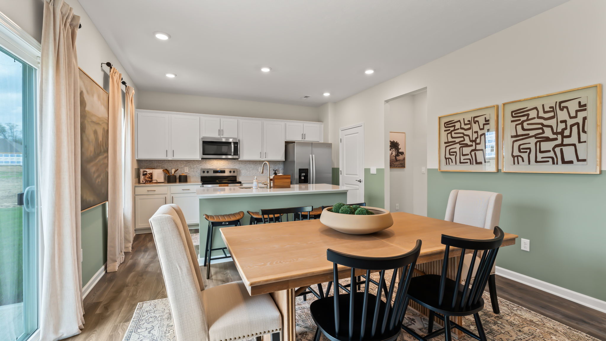 Dining area with green half-wall paint scheme and warm brown table
