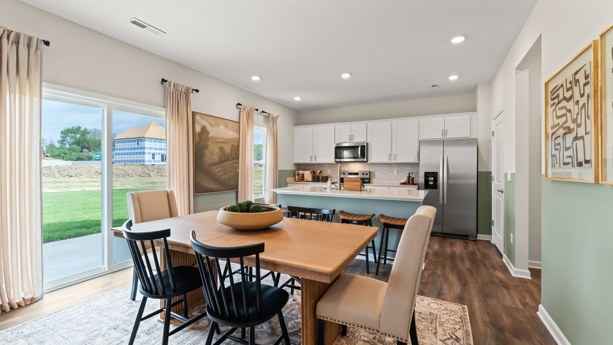 Full kitchen and dining area with natural lighting complimenting brown and green tones