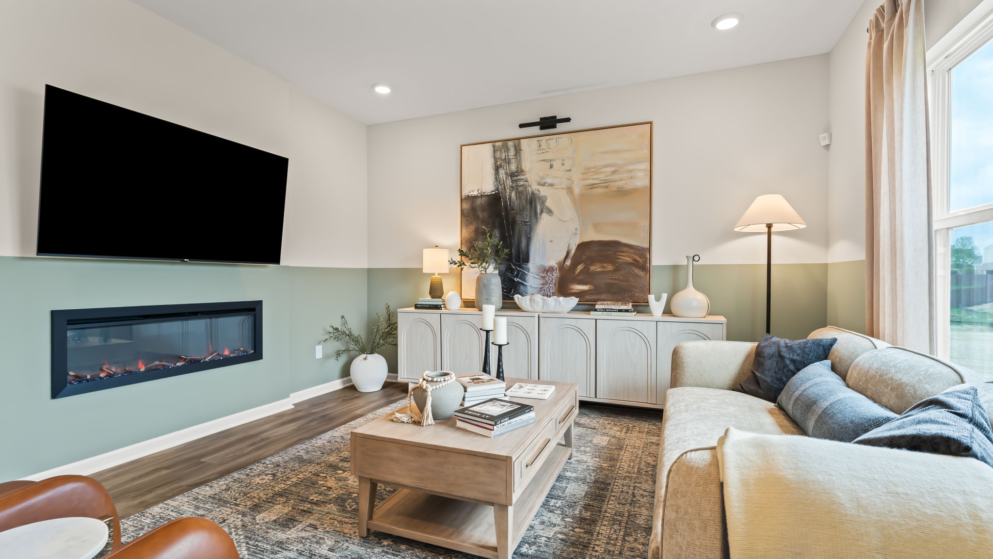 Living room with electric fireplace and farmhouse paintings and furniture