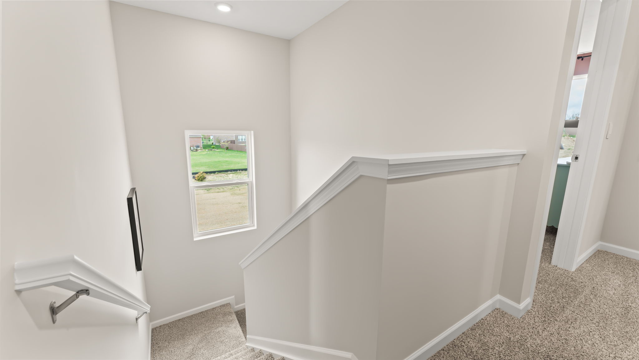 Upstairs landing looking down at stairs with window