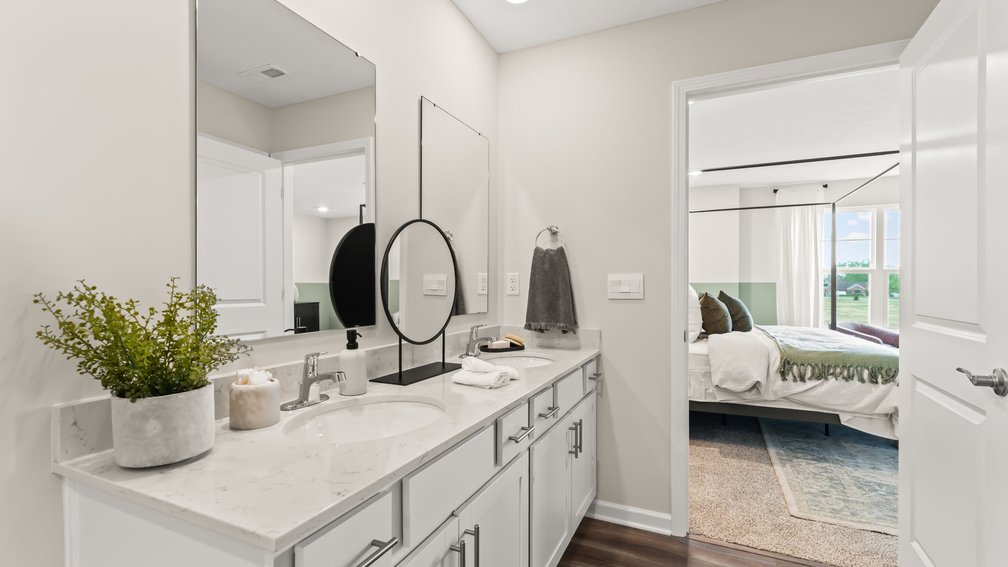 Closeup of double bowl vanity with two mirrors and white countertops
