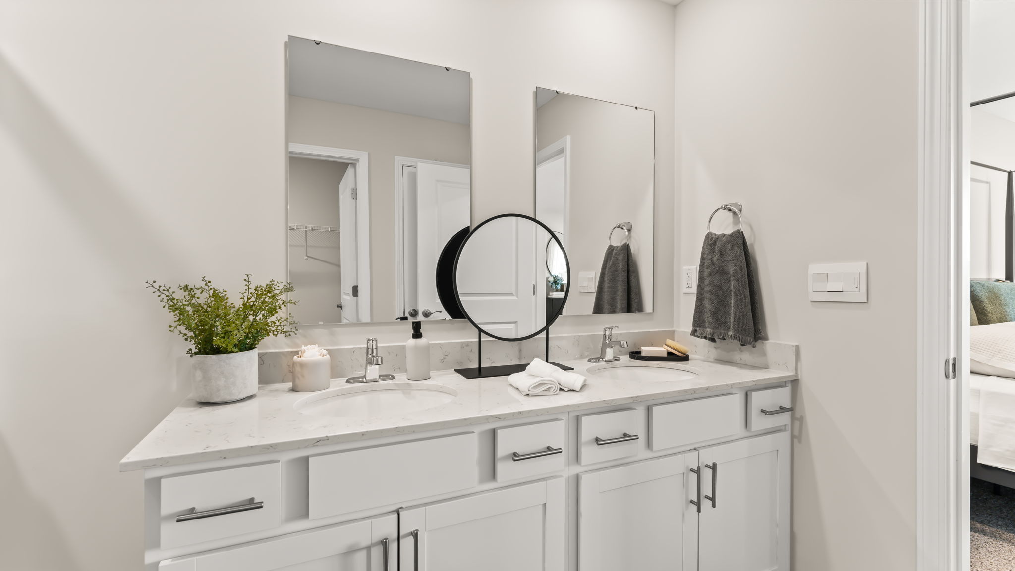 double bowl vanity with two mirrors and white countertops in primary bathroom
