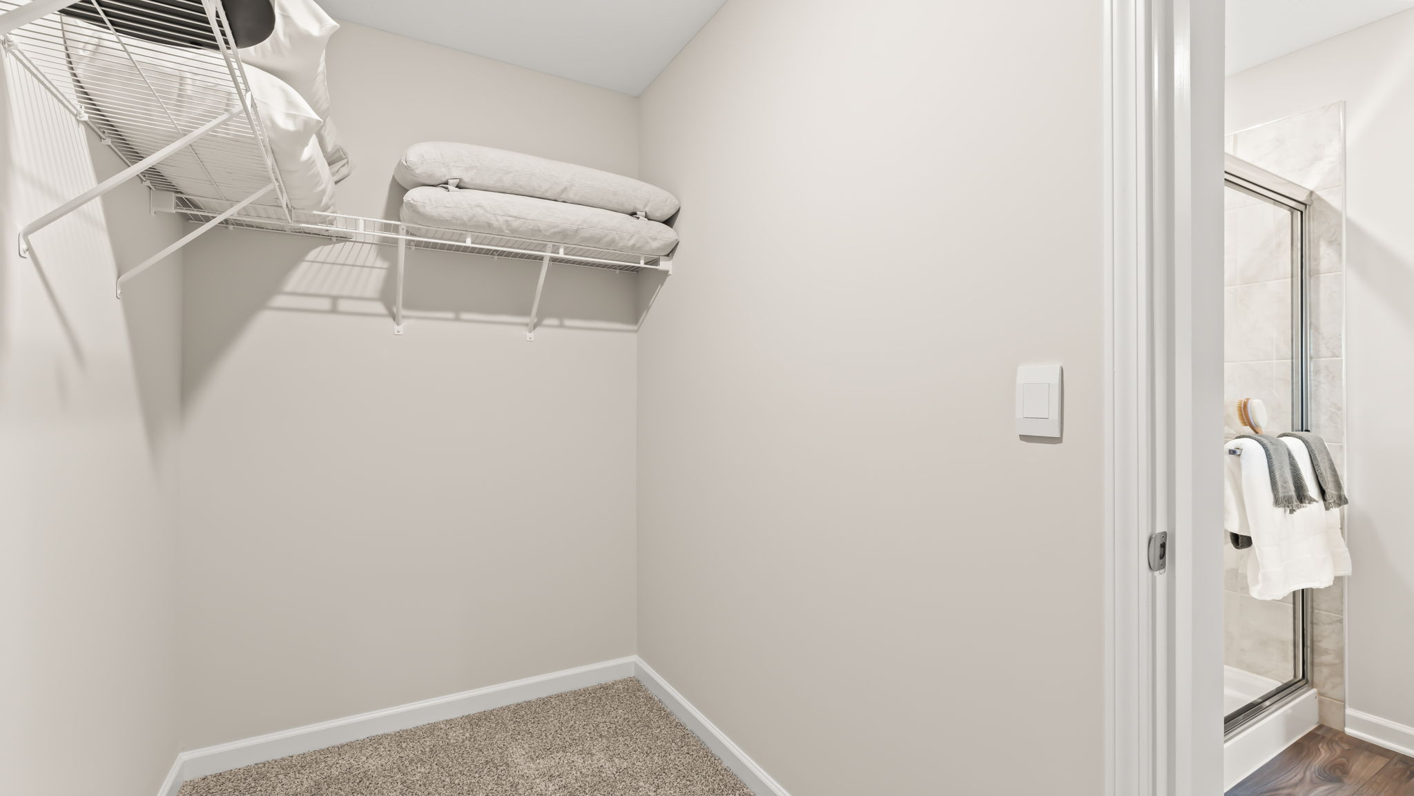 Walk-in closet of primary bathroom suite with wire rack shelving