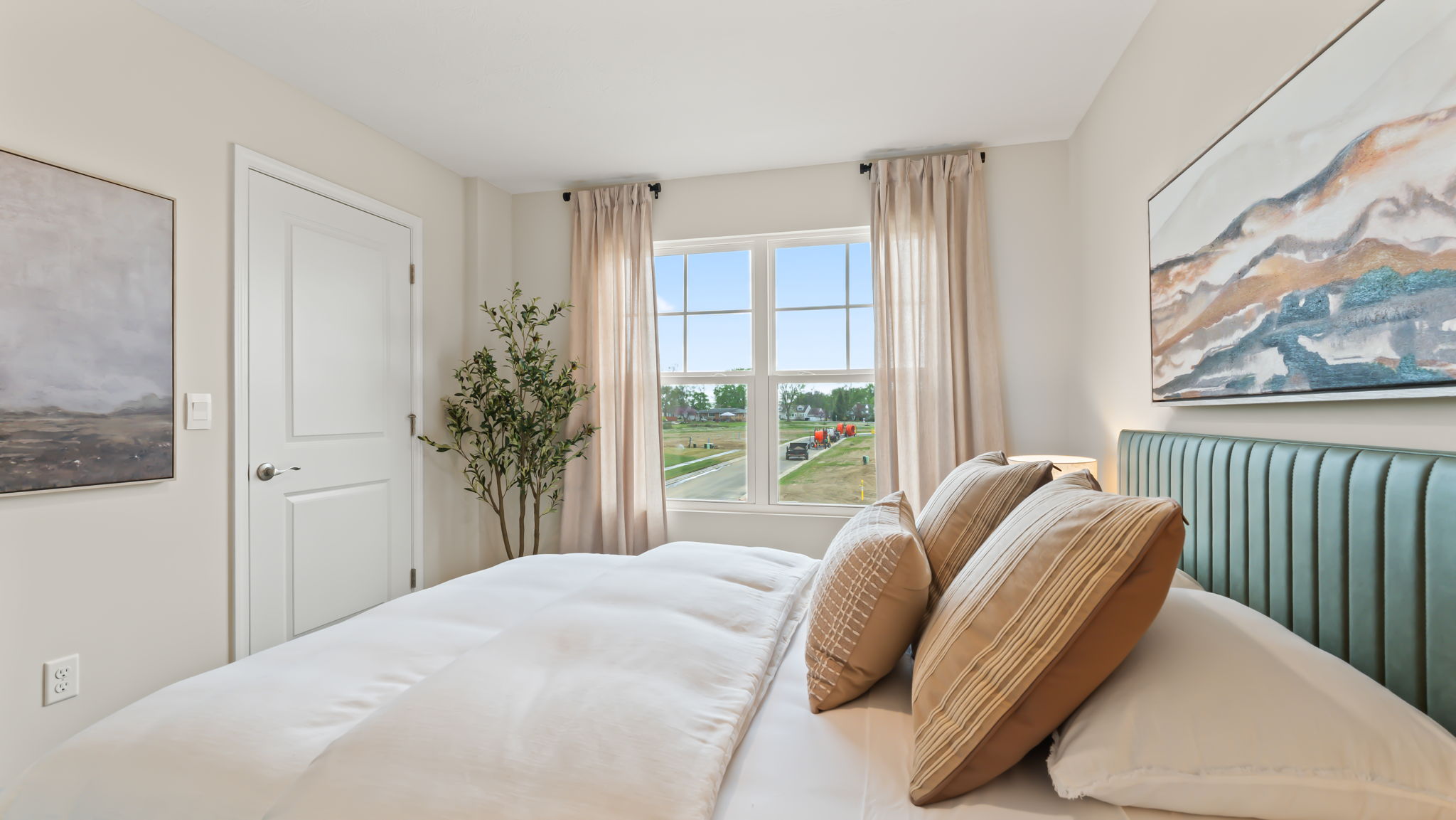 Side view of bedroom with light bedding