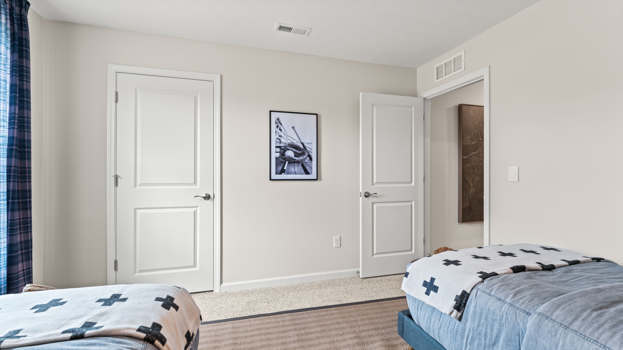 Bedroom with twin beds, closet, and baseball picture on the wall