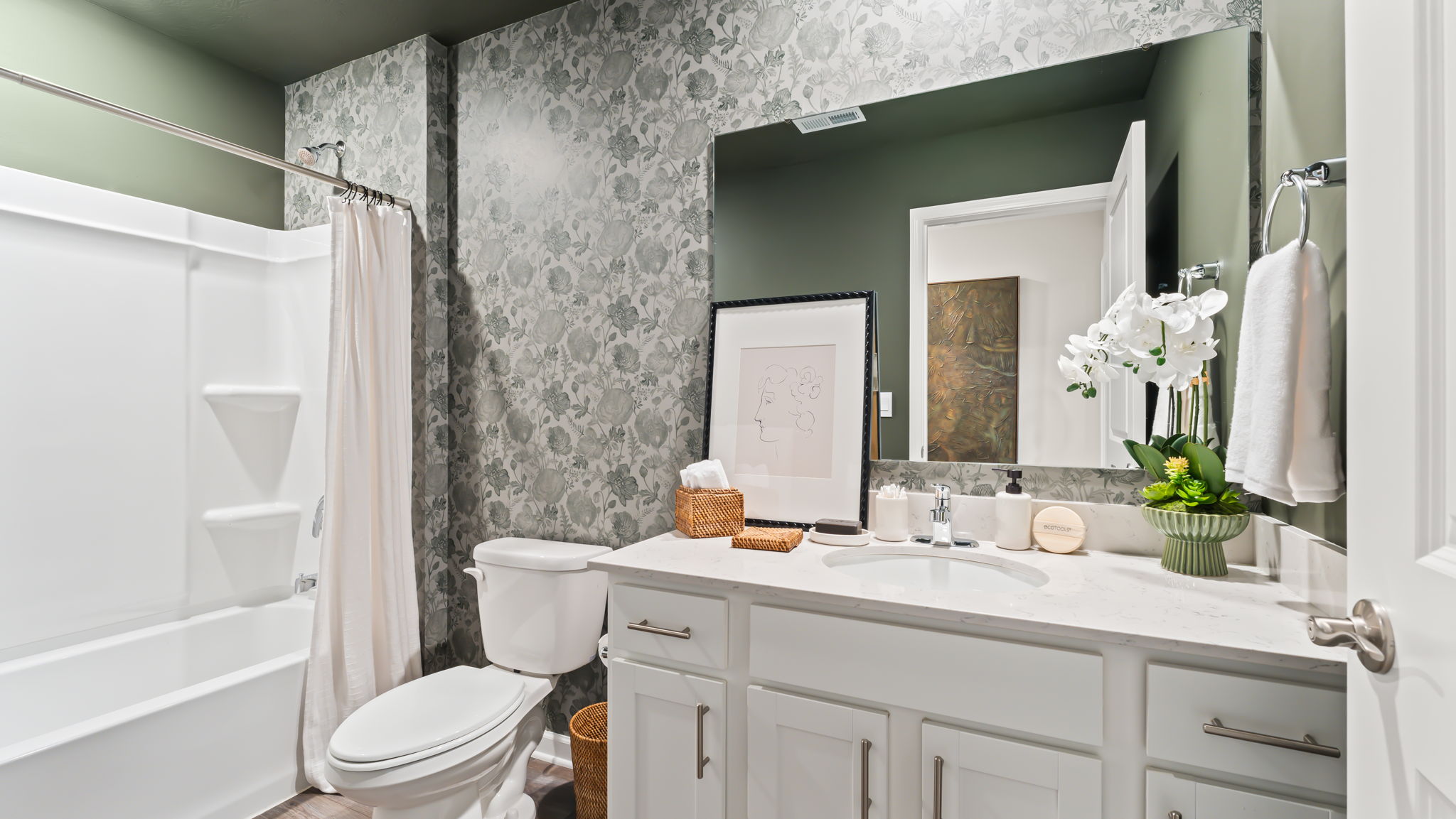Bathroom with green and white walls, tub, toilet, and sink