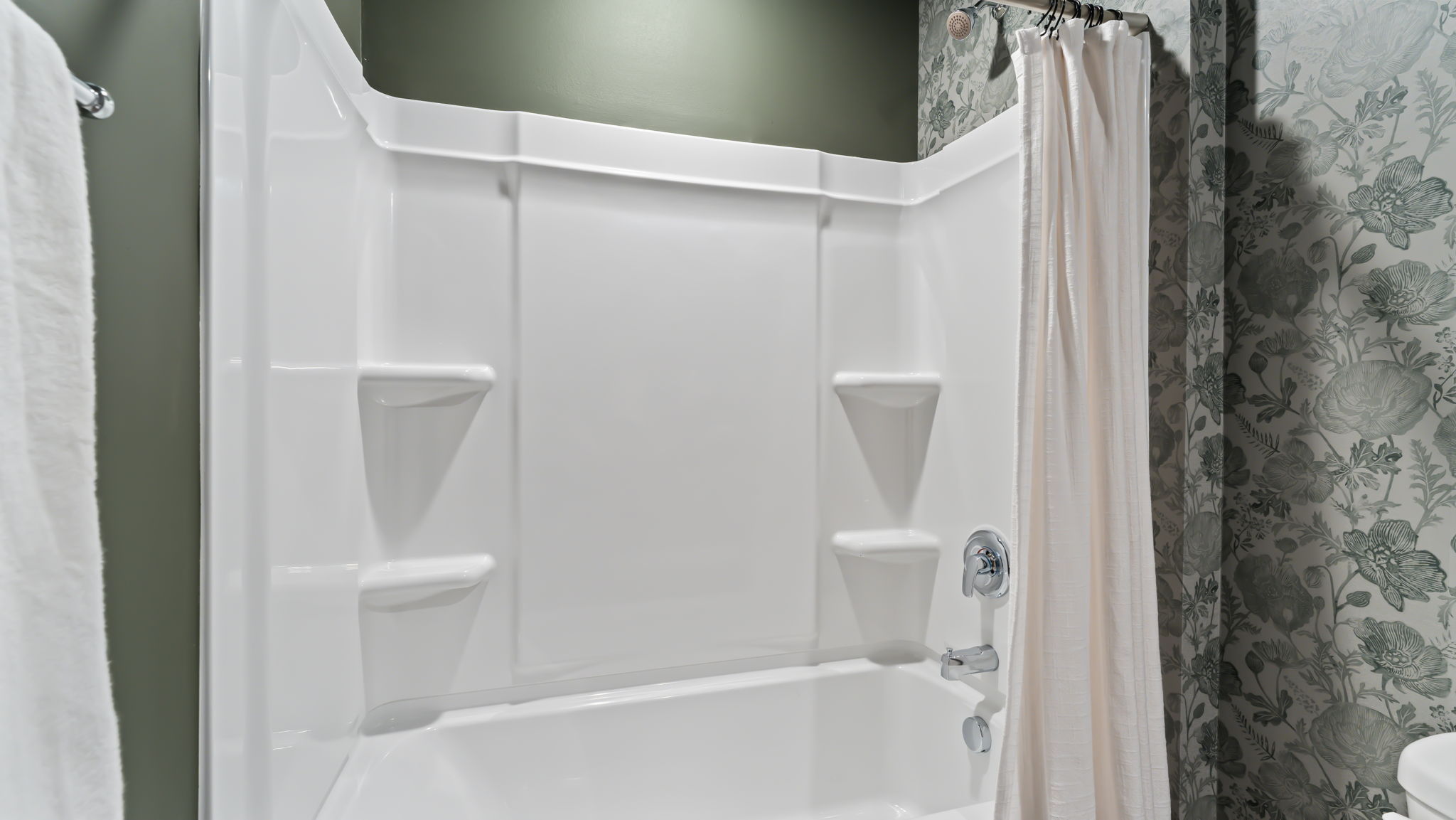Closeup of tub/shower combo with tiered shelving
