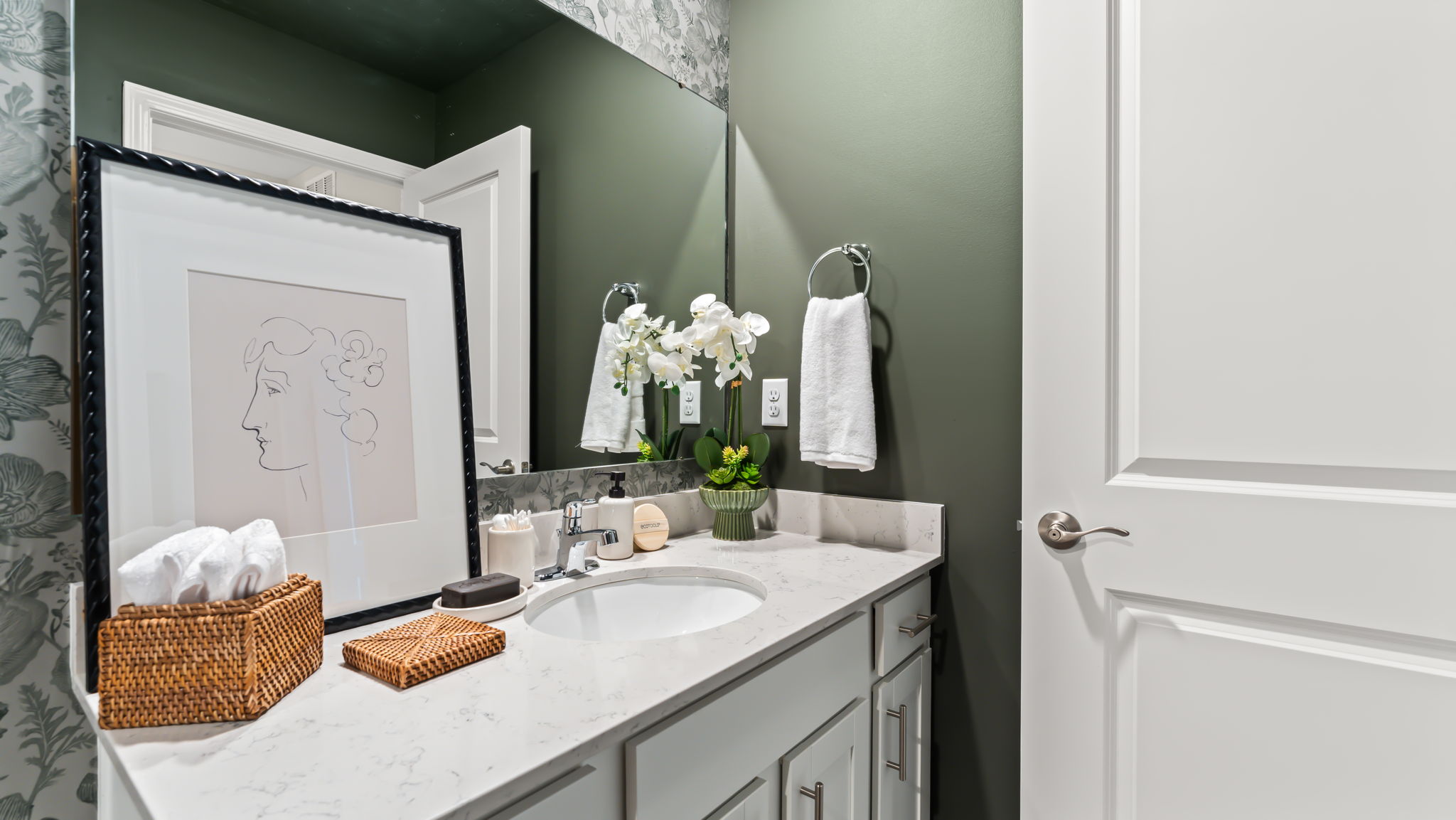 Closeup of bathroom vanity with framed drawing on quartz countertop