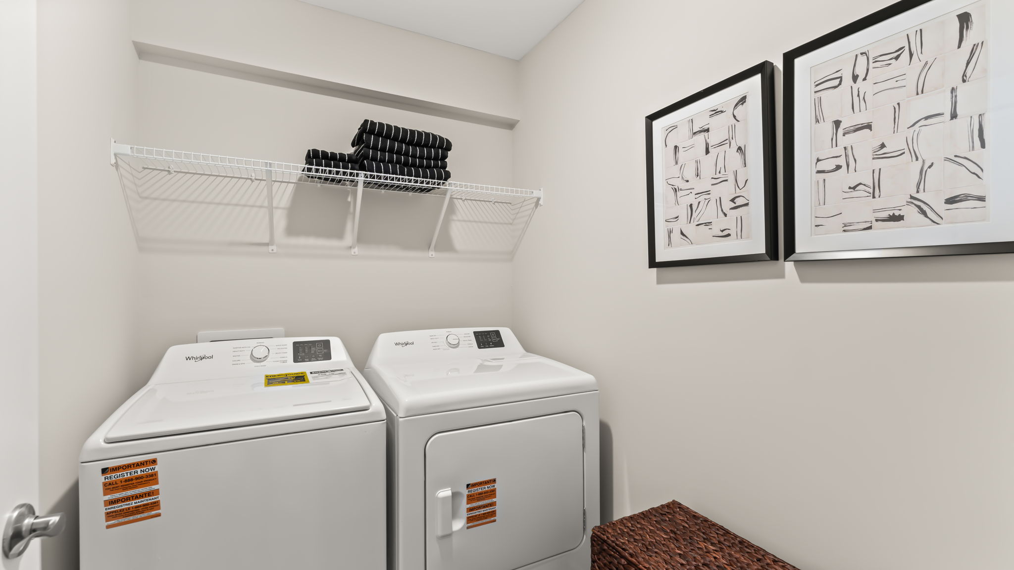 Laundry area with washer/dryer, wire rack shelving, and pin paintings