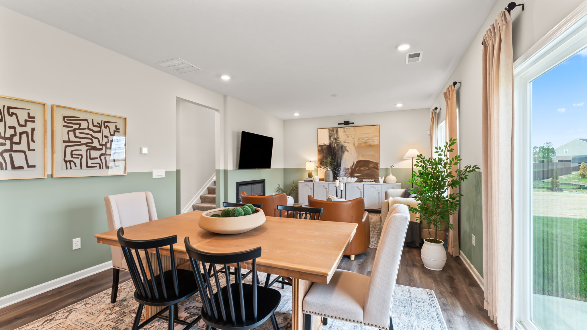 Dining area with green half-wall paint scheme and warm brown table