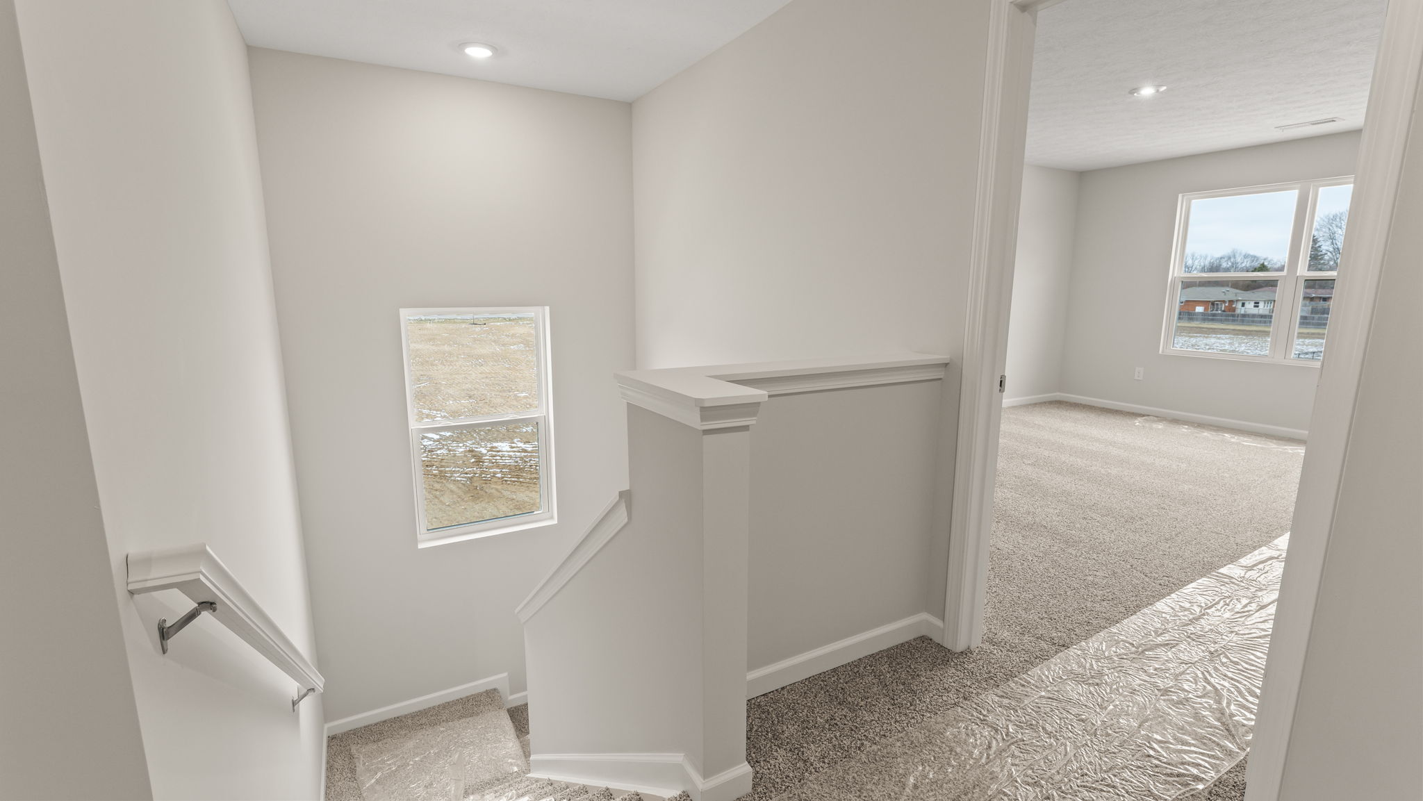 Upstairs landing with view of downstairs and primary bedroom.