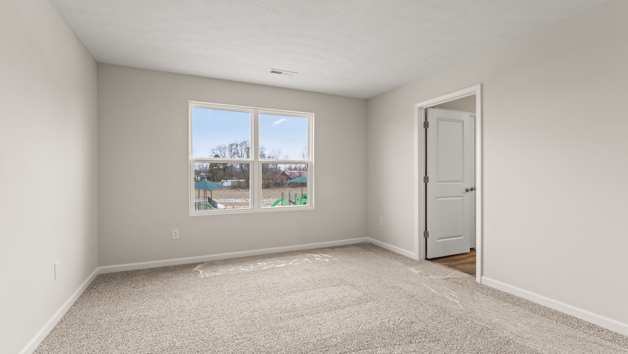Carpeted primary bedroom with view of bathroom