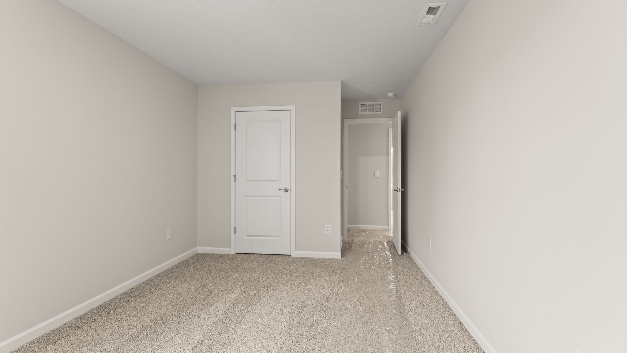 Carpeted bedroom with door to closet.