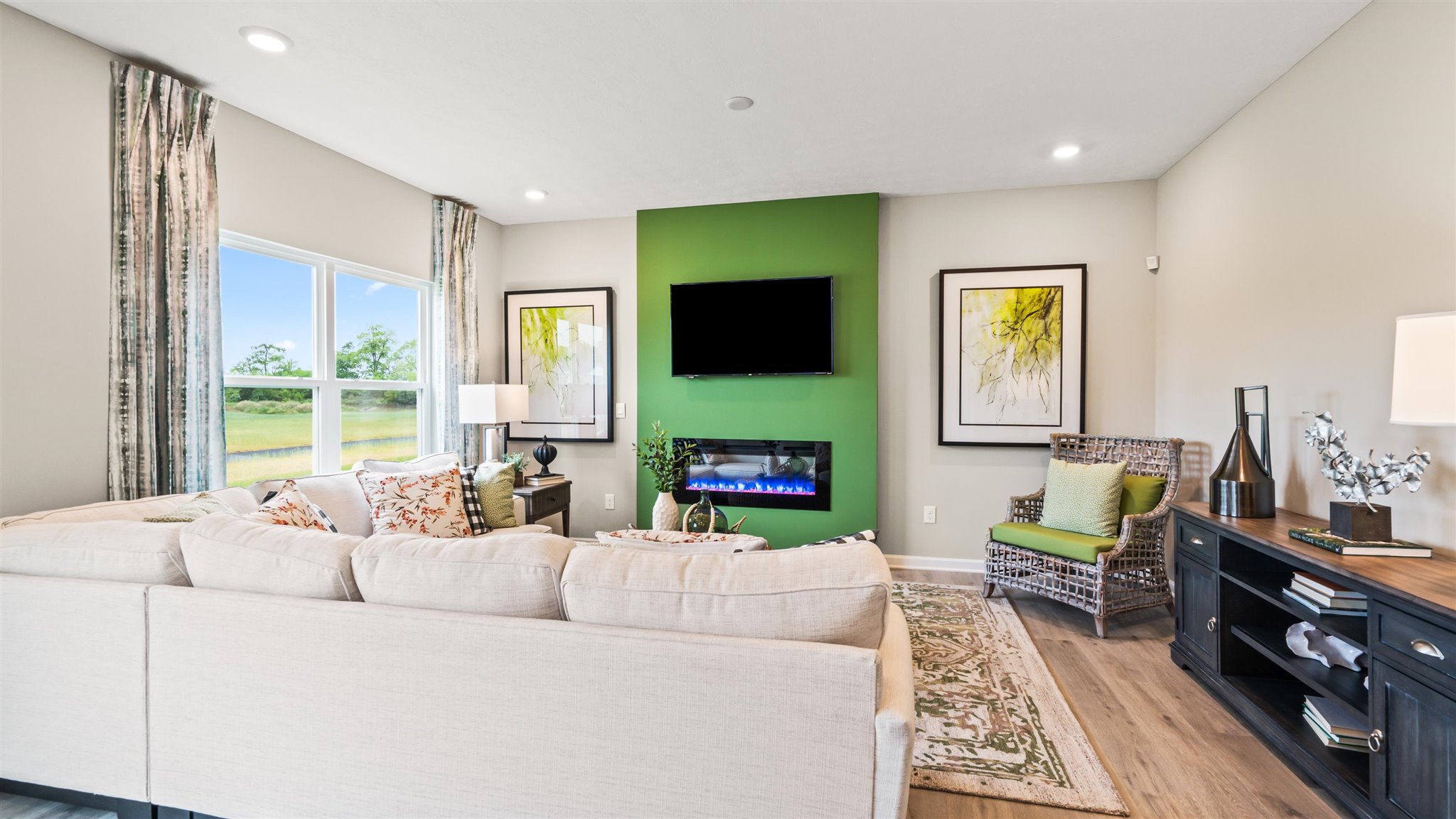 view of casual dining room overlooking the living room with the hallway to the front door in view.  Living room with modern art accents and large lush couch.