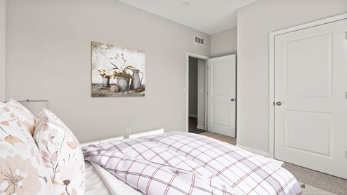 Front bedroom with large bed and decorative art.