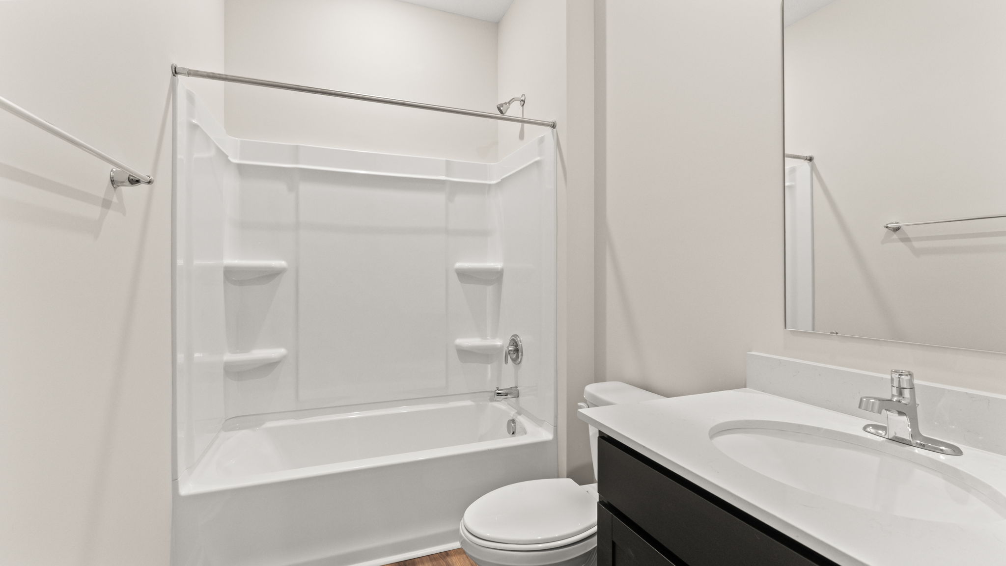 Bathroom with dark cabinets, white countertop, mirror, and mirror