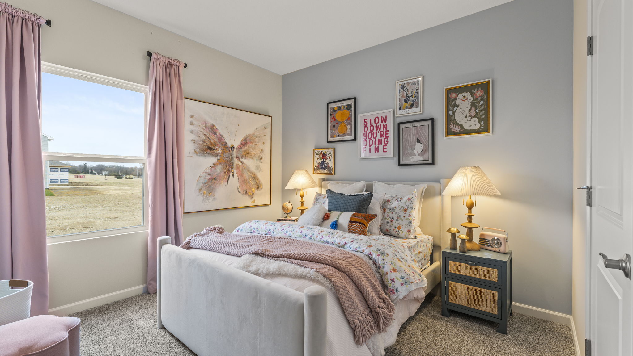 White and pink bedroom with animal-themed art pieces and window to outside.