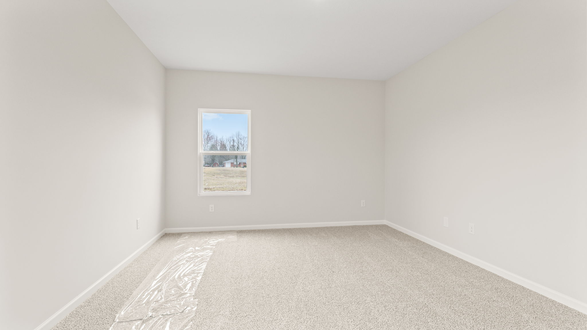 Carpeted primary bedroom with window