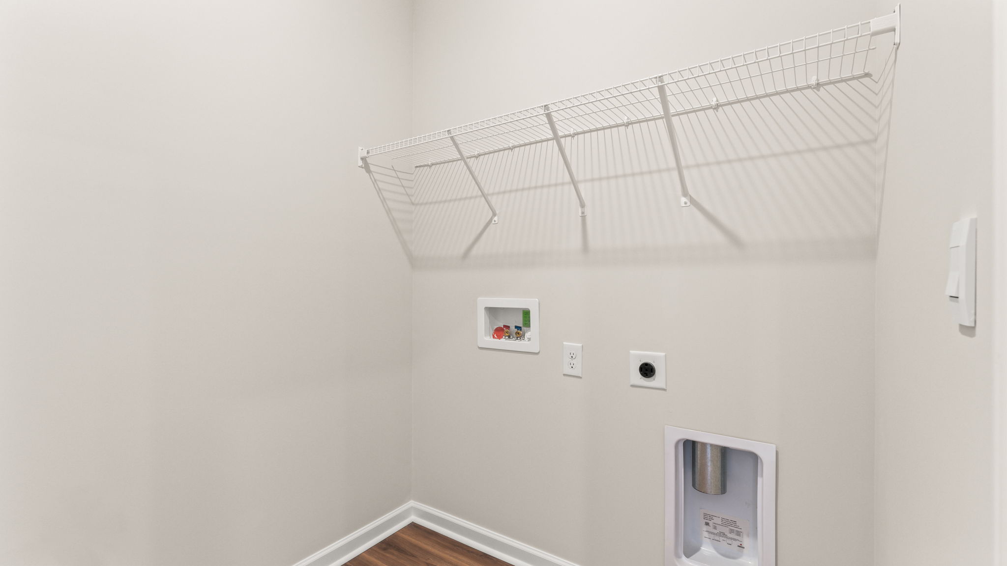 Laundry area with washer/dryer inlets and wire rack shelving