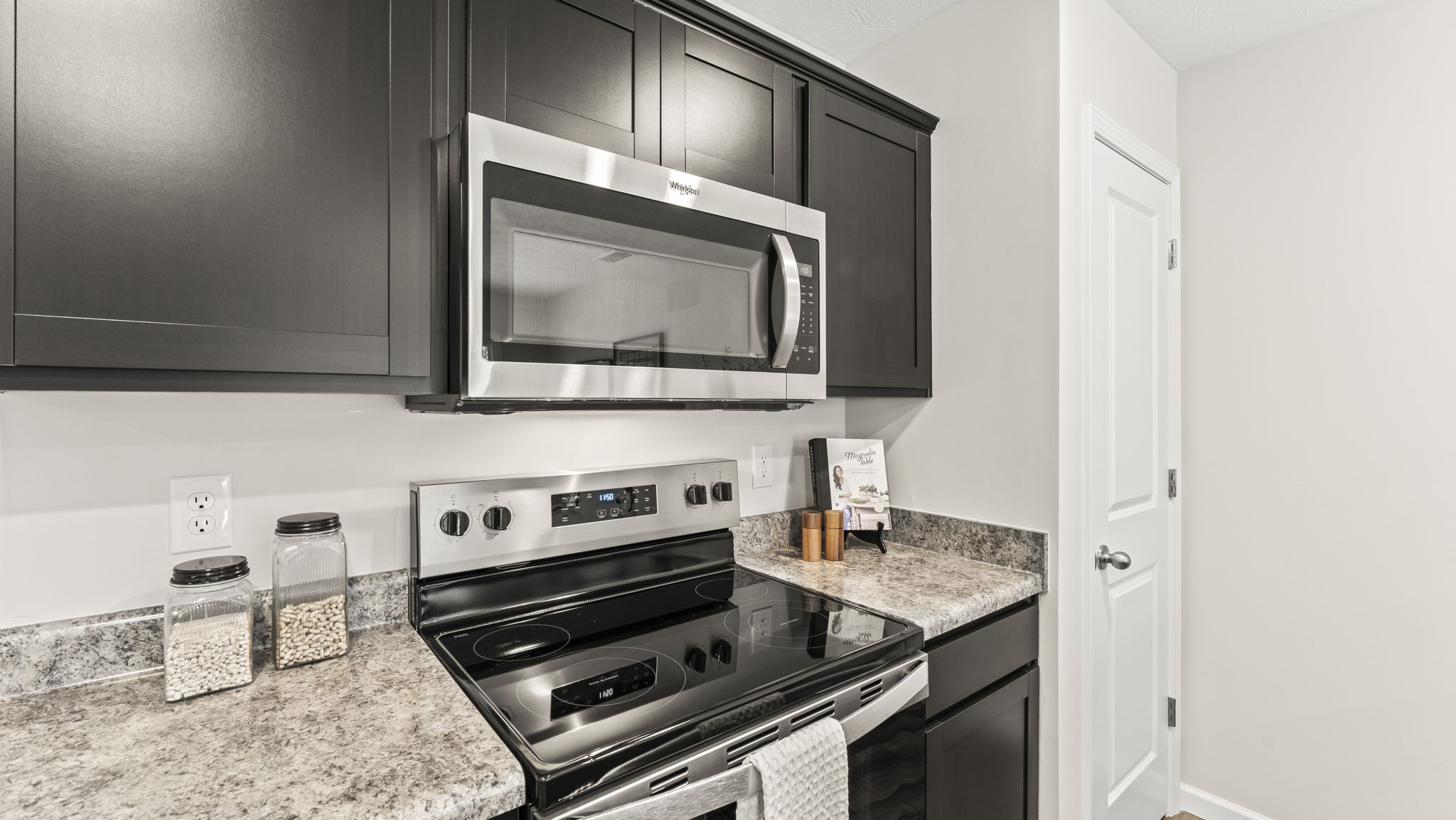 New appliance suite included and central kitchen with sink and seating, next to dining, great room, and outdoor access