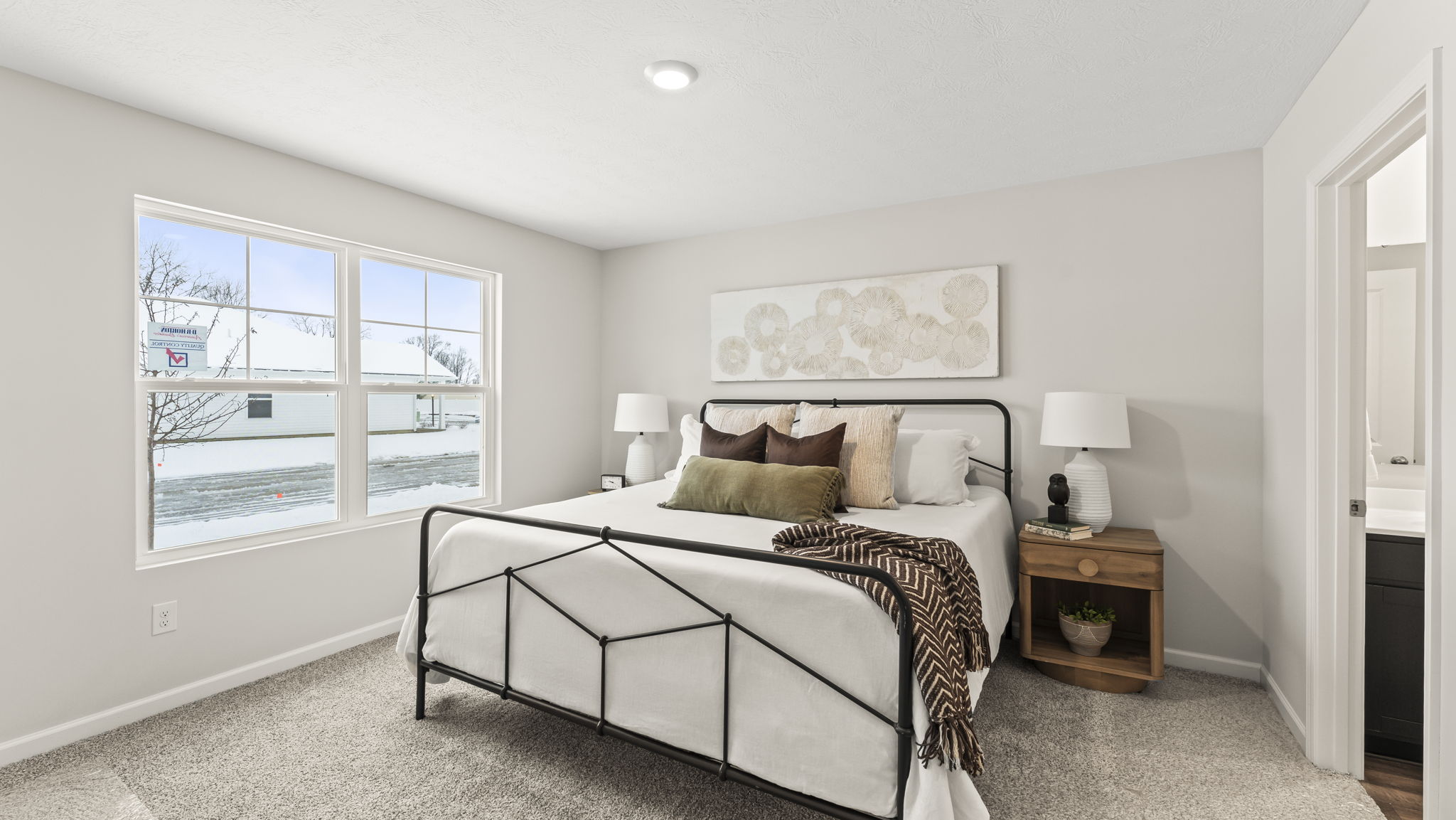 Primary bedroom features ample space, double windows, soft carpet, a stylish walk-in closet, and a private ensuite bath