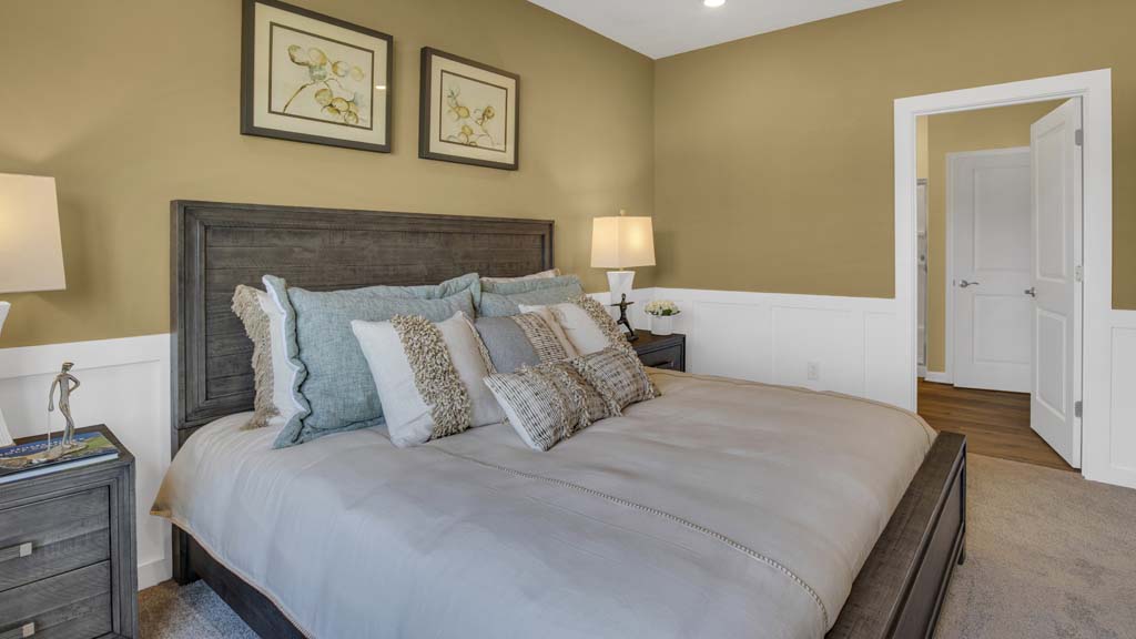 Side view of Primary bedroom with modern art and door into private bath.