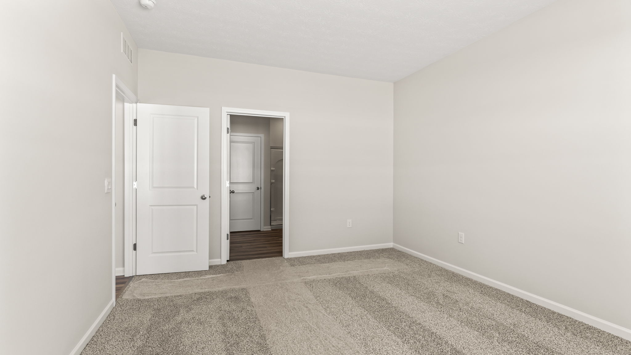 Primary bedroom with view of primary bathroom
