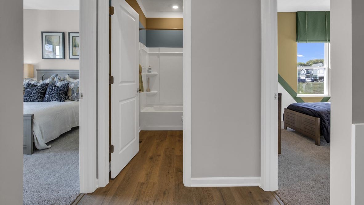 hallway off the left of the foyer with two bedrooms and a shared bathroom.