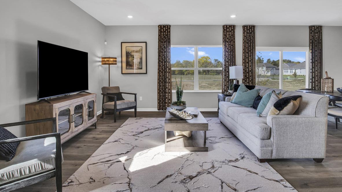 living room with windows into the backyard and comfortable seating.