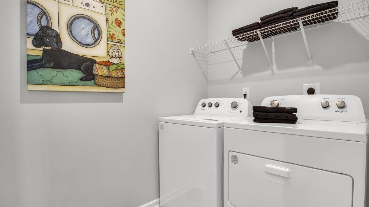 Laundry room with modern art and whirlpool washer and dryer.