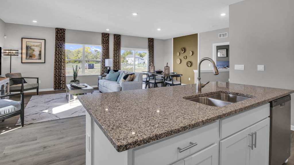 Corner view of kitchen with beautifully decorated open concept great room.