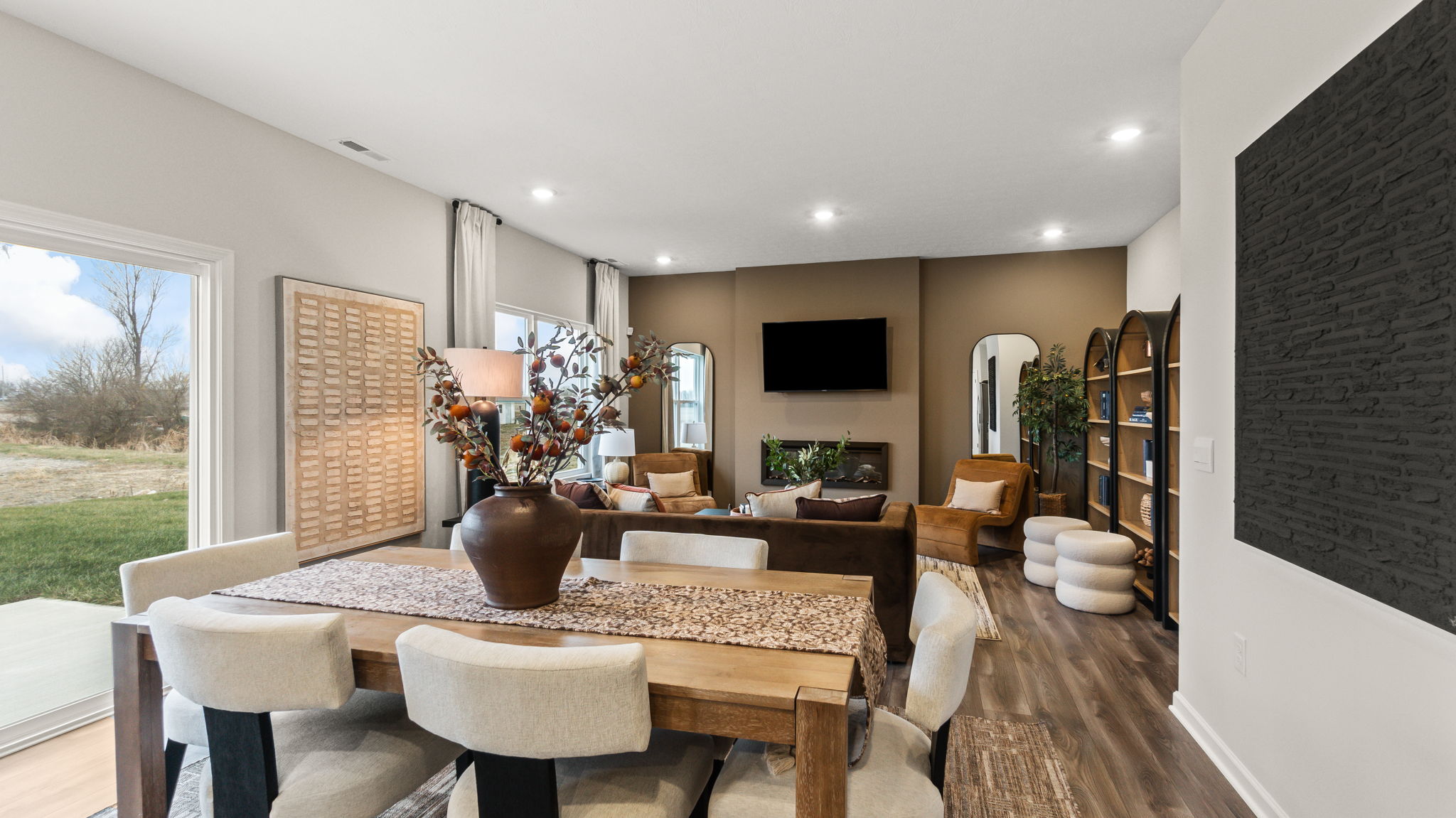 Full living and dining area with modern decoration, earth tones, and contemporary art on the walls.